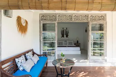 a living room with a blue couch and a bed at Villa Nyama by Optimum Bali Villas in Seminyak