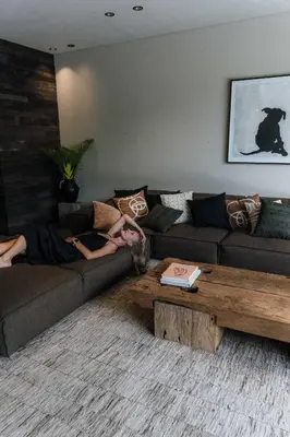 a woman laying on a couch in a living room at Black Villas Canggu Beach by OXO in Canggu
