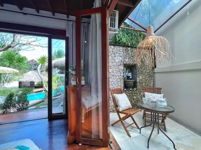a room with a table and chairs and a glass door at Villa Nicole 5BR Paradise, quiet area in Central Oberoi Seminyak in Seminyak