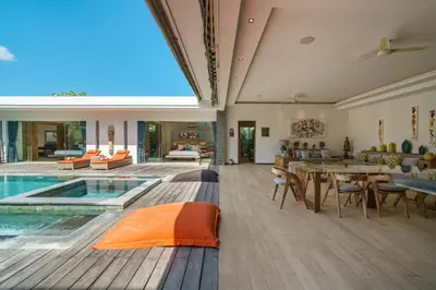 a large living room with a pool and a table at Villa Harlow: Stylish 3BR Villa - Centrally Located in Berawa in Canggu