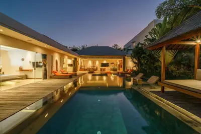 a swimming pool in a house with a wooden deck at Villa Harlow: Stylish 3BR Villa - Centrally Located in Berawa in Canggu
