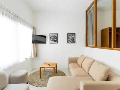 a living room with a couch and a mirror at Berawa Village Suite in Canggu