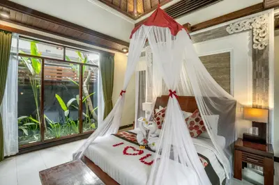 a bedroom with a bed with a mosquito net at The Bali Dream Suite Villa Seminyak in Seminyak