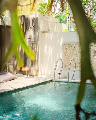 a swimming pool with two metal faucets at Hola Seminyak in Seminyak