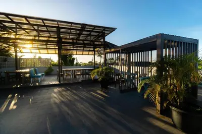 a patio with tables and chairs on a building at Hola Seminyak in Seminyak