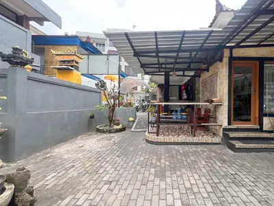 a building with awning next to a street at RedDoorz at Mahendra Beach Inn Kuta in Kuta