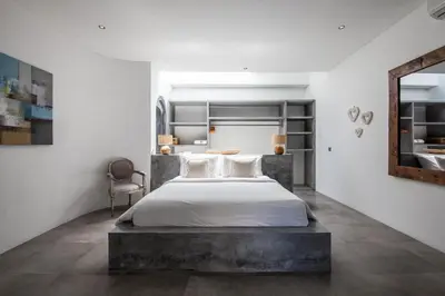 a bedroom with a large bed and a mirror at Villa Xaloc by House of Winds - Stunning Balinese retreat next to Canggu in Kerobokan