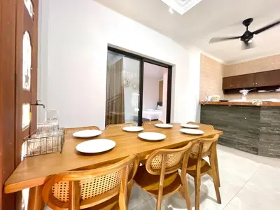 a dining room with a wooden table and chairs at Satran Villa @ Kuta Bali in Legian