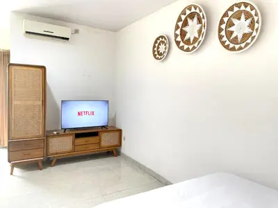 a room with a tv on a wall at Satran Villa @ Kuta Bali in Legian