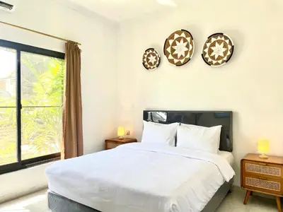 a bedroom with a bed and two clocks on the wall at Satran Villa @ Kuta Bali in Legian