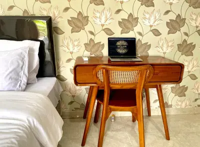 a desk with a laptop on it in a bedroom at Satran Villa @ Kuta Bali in Legian