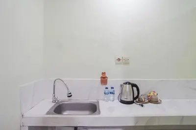 a kitchen counter with a sink and a tea kettle at Kos 168 Jimbaran in Jimbaran