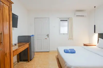 a bedroom with a bed and a desk and a computer at Kos 168 Jimbaran in Jimbaran