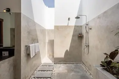 a bathroom with a shower with a stone floor at Villa Bahia by Optimum Bali Villas in Seminyak