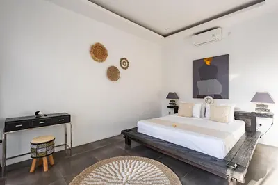 a bedroom with a large white bed and a table at Villa Bahia by Optimum Bali Villas in Seminyak
