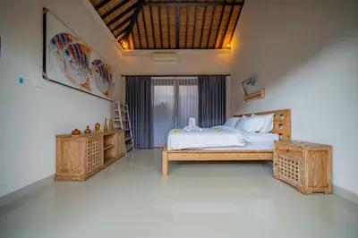 a bedroom with a white bed and a large window at 4BR w/ Pool- Ultimate Comfort in Umalas in Kerobokan