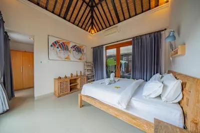 a bedroom with a large bed with white pillows at 4BR w/ Pool- Ultimate Comfort in Umalas in Kerobokan