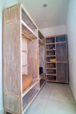a room with a large wooden closet with shelves at Simple & Magical Villas PRAYA in Seminyak
