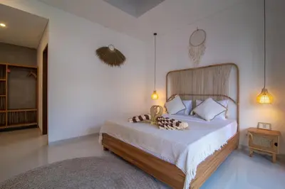 a bedroom with a large bed with a wooden headboard at Simple & Magical Villas. Villa Sambali llI in Seminyak