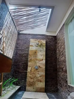 a room with a brick wall and a ceiling at Villa alula in Seminyak