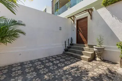 a staircase leading to a building with a wooden door at Villa Serenity: modern design luxury 12m pool and BBQ in Seminyak