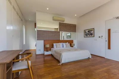 a bedroom with a bed and a desk in it at Villa Serenity: modern design luxury 12m pool and BBQ in Seminyak