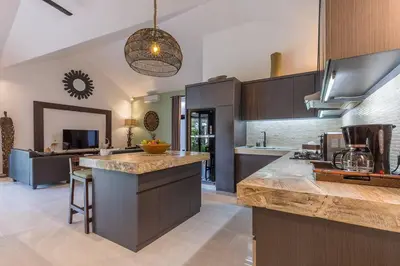 a kitchen with wooden cabinets and a counter top at Villa Budha 2 4bedrs 12m Pool, 700m2 garden&BBQ, central & quiet in Seminyak