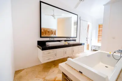 a bathroom with a white sink and a large mirror at Kencana Villa Seminyak in Seminyak