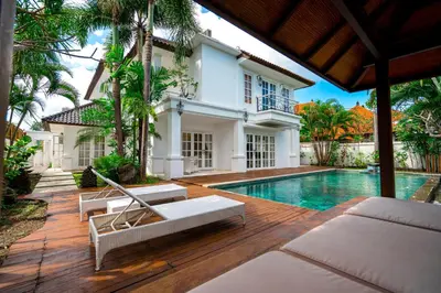 a villa with a swimming pool and a house at Kencana Villa Seminyak in Seminyak