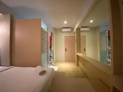 a hotel room with a bed and a hallway at Kimono Spa Hotel in Kuta
