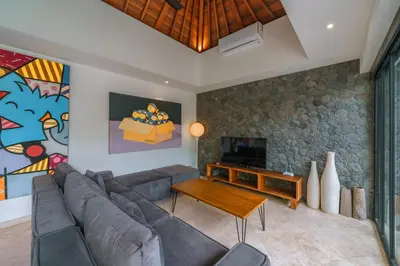 a living room with a couch and a tv at Villa Yasmee : Cozy and Modern 2 BR w/ Pool in Seminyak ! in Seminyak