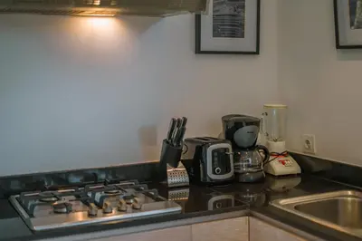 a kitchen counter with a stove top oven next to a sink at Villa Anahata: Modern 2BR Villa w/ Pool in Seminyak ! in Seminyak