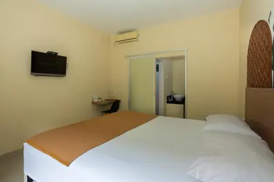 a bedroom with a bed and a flat screen tv at Cove Kanaya in Denpasar