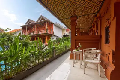a balcony with a table and chairs and a building at Lumbung Sari Hotel Legian in Legian
