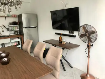 a living room with a table and a fan and a refrigerator at Villa Denira in Nusa Dua