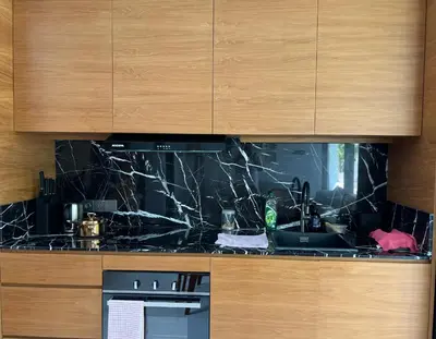 a kitchen with a black counter top with a sink at T villa in Seminyak