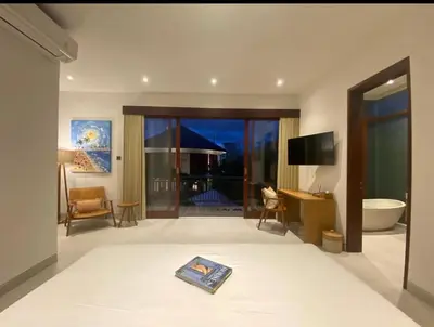a room with a bathroom with a tub and a television at T villa in Seminyak