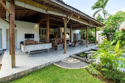 an outdoor living room with a large wooden pergola at Villa Aniri - Seminyak Villa - Walk to Beach & Cafés in Seminyak