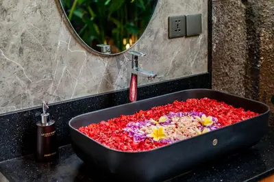 a bath tub filled with flowers in a bathroom at Le Cielo Resort Umalas by Maviba in Canggu