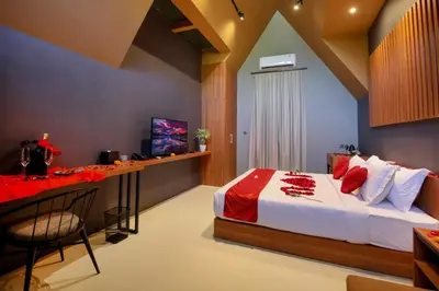 a bedroom with a bed and a desk with a television at Le Cielo Resort Umalas by Maviba in Canggu
