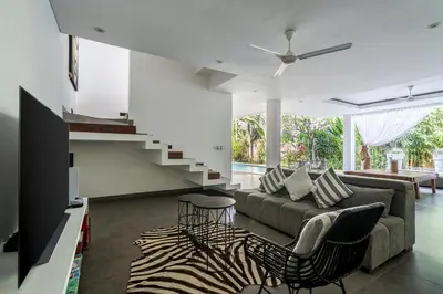 a living room with a couch and a staircase at Villa Alopa 1 in Seminyak