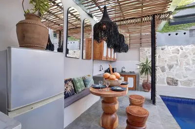 a kitchen with a table and a refrigerator at Seminyak Beach Bungalow Studio #2 with Private Pool in Seminyak