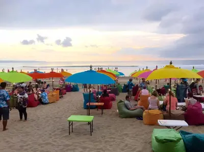 a group of people sitting under umbrellas on a beach at Seminyak Beach Bungalow Studio #2 with Private Pool in Seminyak