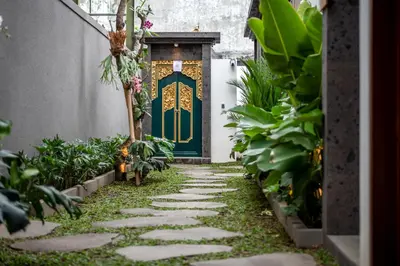 a walkway leading to a door in a garden at Pondok Arya Kuta Villas by Kamara in Kuta