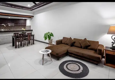 a living room with a brown couch and a table at Pondok Arya Kuta Villas by Kamara in Kuta