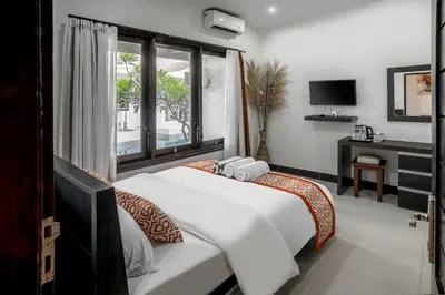 a bedroom with two beds and a window at Pondok Arya Kuta Villas by Kamara in Kuta