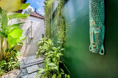 a view of a garden with plants and a building at Villa Balissima in Seminyak
