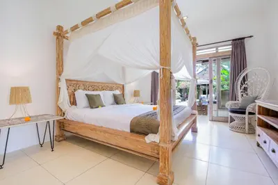a bedroom with a four poster bed with a canopy at Villa Balissima in Seminyak