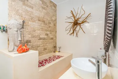 a bathroom with a bath tub and a sink at Villa Balissima in Seminyak