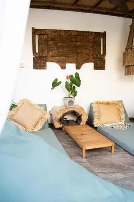 a room with two beds and a table with a potted plant at Villa Loba in Seminyak